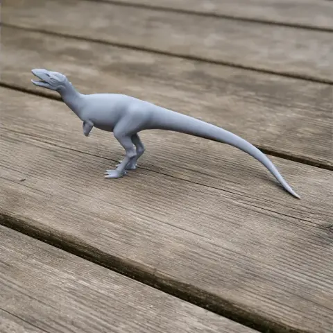 Gray 3D-printed model of a prehistoric reptile on a wooden surface.