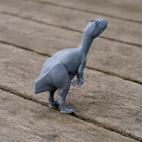 Gray 3D-printed Apatodon model standing on a wooden surface.