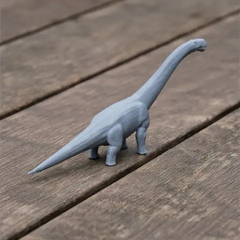 A 3D printed model of a long-necked dinosaur, resembling a sauropod, on a wooden surface.