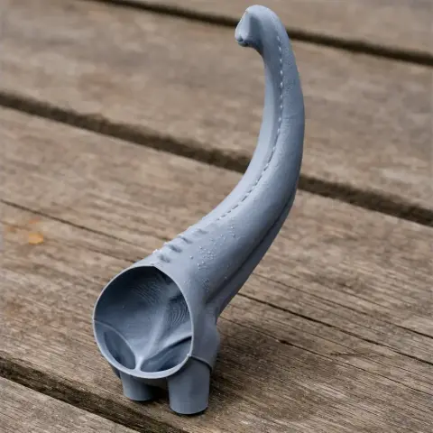 A 3D-printed model of a dinosaur neck and head, partially shown, on a wooden surface.