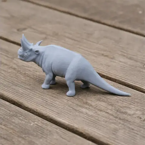 Gray 3D-printed model of an Arsinoitherium on a wooden surface.