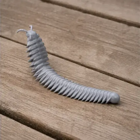 Gray 3D-printed model of an Arthropleura, a segmented prehistoric creature, on a wooden surface.