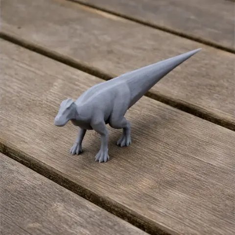 3D printed prehistoric animal model with a long tail on a wooden surface.