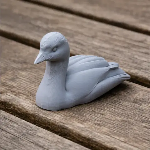 3D printed model of an Australasian grebe, depicted in a resting pose on a wooden surface.