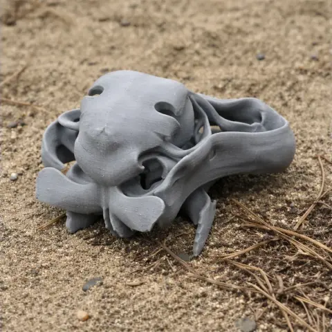 3D-printed dodo skull replica resting on sand.