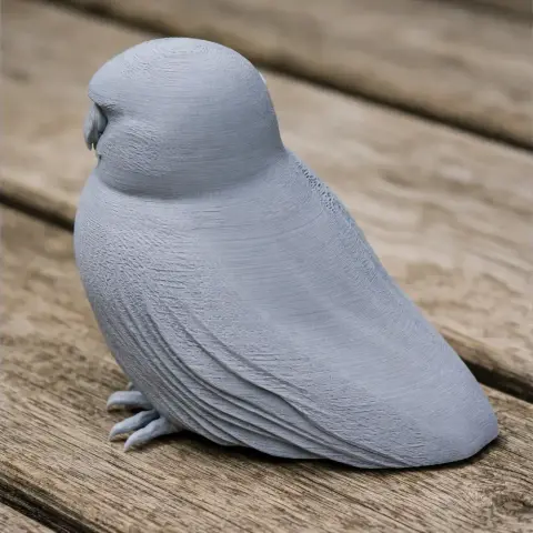 3D-printed model of an Australian boobook, a small owl, shown on a wooden surface.