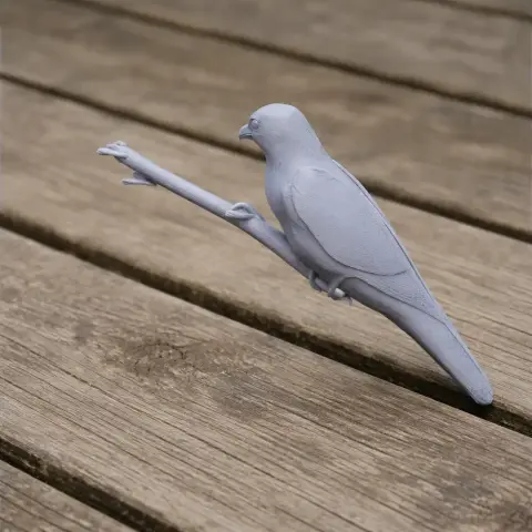 A detailed 3D printed model of a bird perched on a branch, placed on a wooden surface.