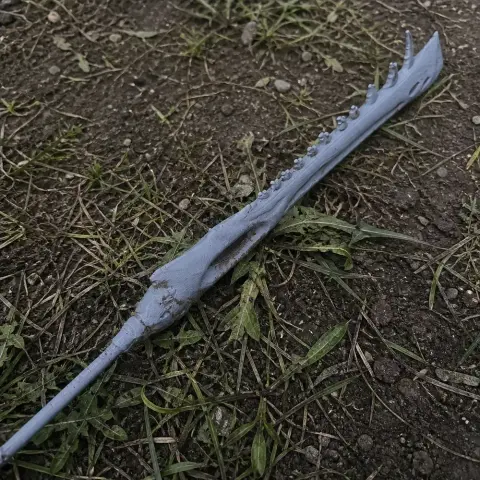 A long, jagged, bone-like cosplay sword prop lies on the ground.