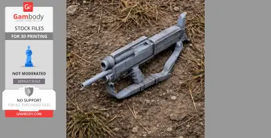 Gray 3D-printed sci-fi gun model on dirt and grass surface.