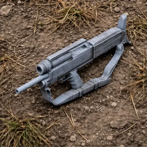 A 3D-printed High Standard Model 10 prop gun lies on dirt and grass.