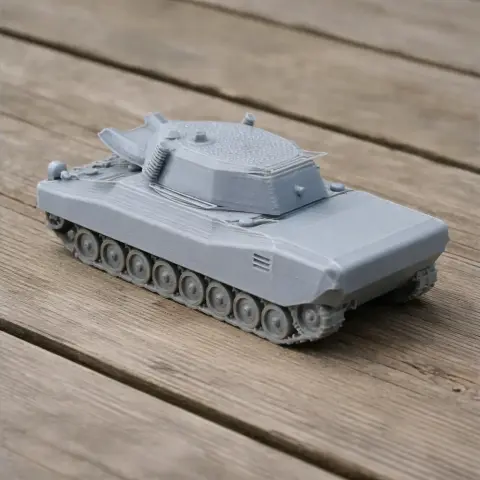 Gray 3D-printed model of a CCV-L light tank, featuring a turret and detailed tracks on a wooden surface.