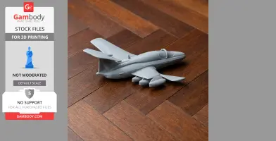 A 3D-printed model of the Aero L-29 aircraft in gray, displayed on a wooden surface.