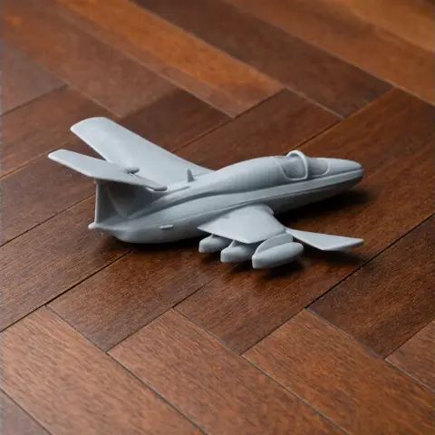 Gray 3D printed model of an Aero L-29A Akrobat jet, displayed on a wooden surface.