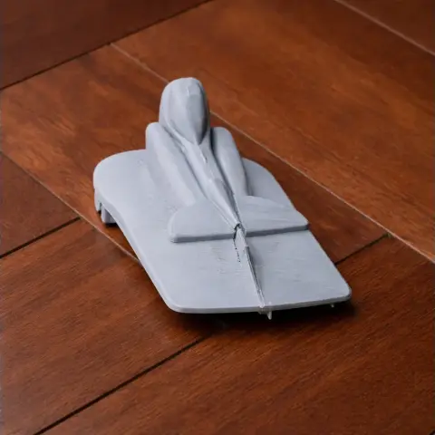 Gray 3D-printed model of a jet-like vehicle on a wooden surface.