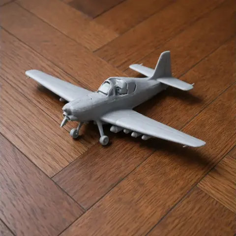 A gray 3D-printed model airplane on a wooden floor.