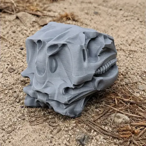 3D-printed Scelidosaurus skull replica in gray, placed on sandy ground.