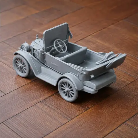 3D-printed antique car model with open top and detailed wheels on a wooden surface.