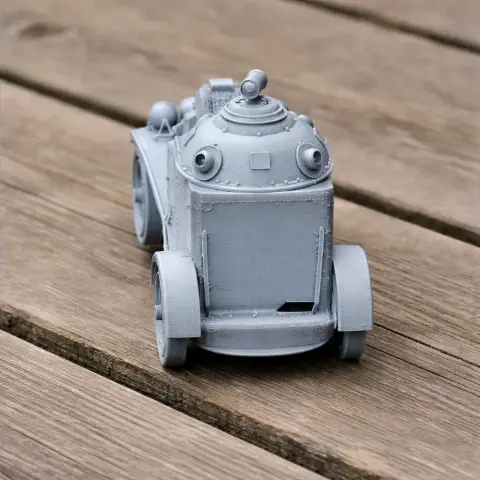 A gray, detailed 3D printed model of a vintage armored car on a wooden surface.