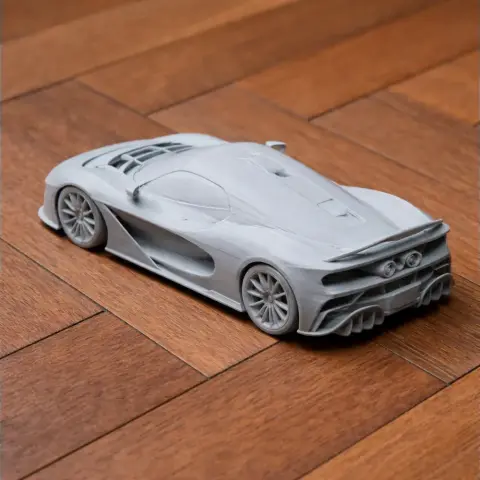 3D-printed model of a sleek, modern sports car on a wooden surface.