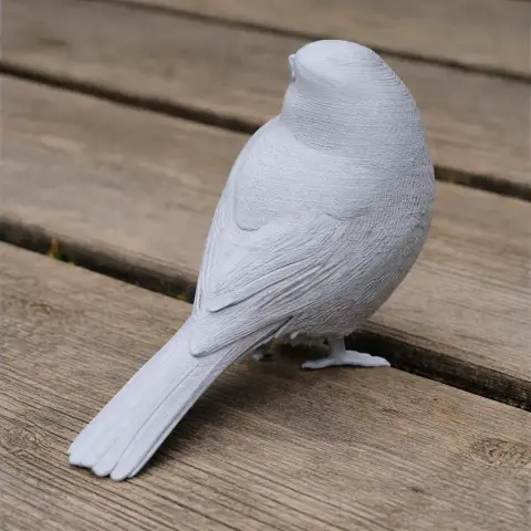 3D-printed model of a bird resembling a tit, posed on a wooden surface.