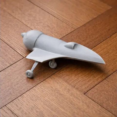 Gray 3D-printed model of the Aviatika-900 Acrobat airplane, resting on a wooden surface.