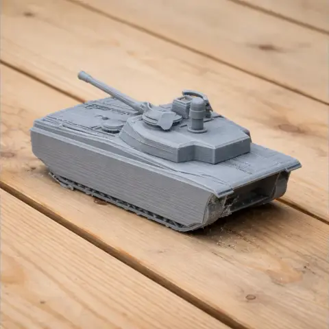 Gray 3D-printed model of a CV90 tank on wooden surface.