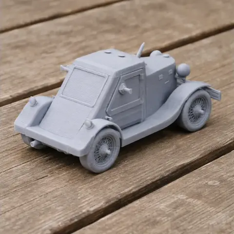 3D-printed model of a D-8 armored car with detailed wheels and a simplistic design on wooden surface.