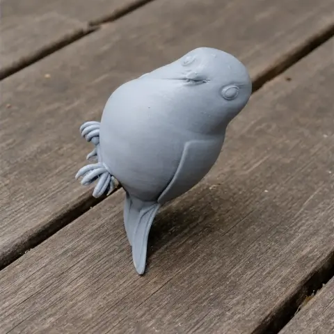 3D printed model of a bird with a round body and tail, standing on a wooden surface.