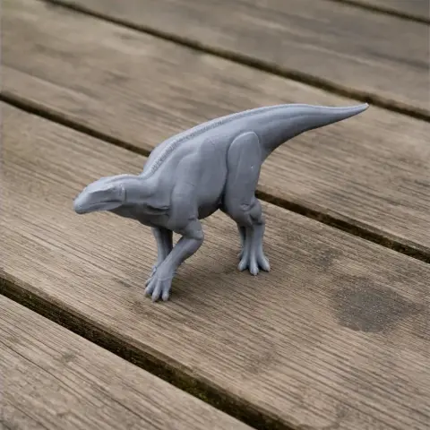 Gray 3D-printed Bactrosaurus model posed on a wooden surface.