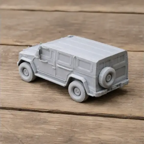 3D-printed model of a gray, boxy armored vehicle on a wooden surface.