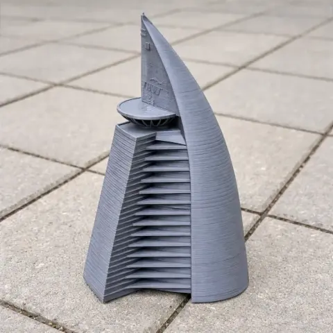 Gray 3D-printed Telekom Tower model with a sleek, futuristic design on a tile surface.