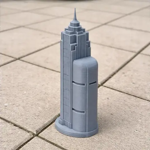 A detailed 3D-printed model of a tall, modern skyscraper with a tiered spire, set on a tiled surface.