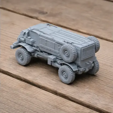 3D-printed Casspir tank model with prominent tires on a wooden surface.