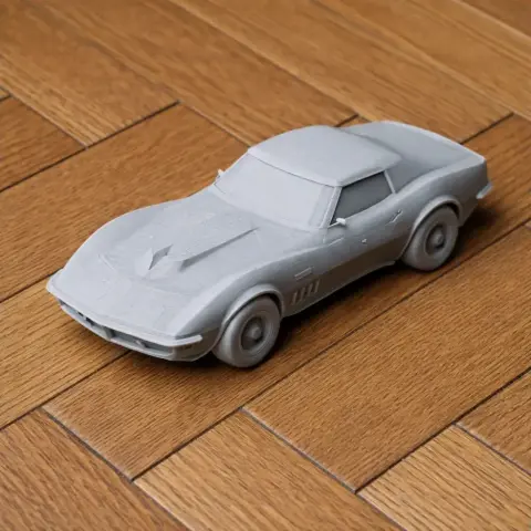 3D printed model of a Chevrolet Astrovette on a wooden surface, unpainted and detailed.