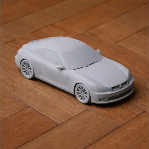 3D printed model of a Chrysler Crossfire car on a wooden surface.