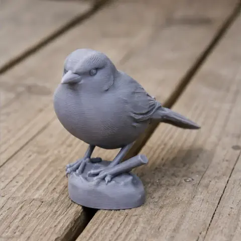A detailed 3D-printed model of a bird perched on a small base, designed for a natural, realistic appearance.