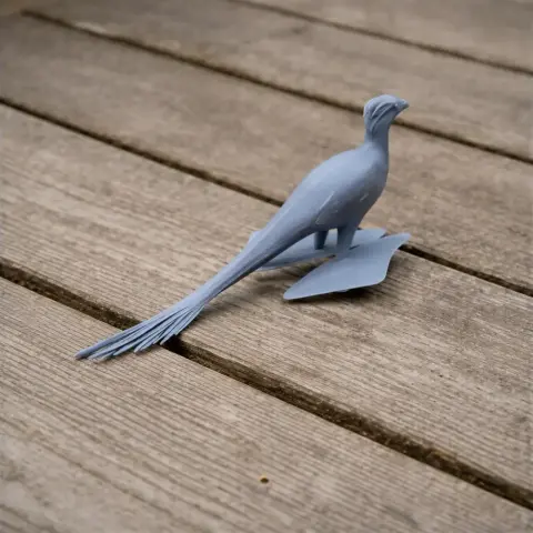 Gray 3D-printed model of a Balaur, a prehistoric bird-like creature, on a wooden surface.