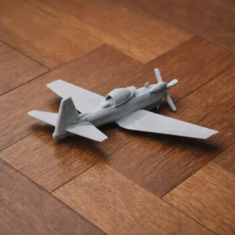 3D printed model of a small propeller aircraft on a wooden surface.