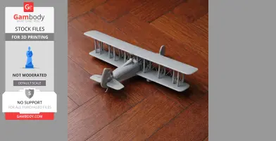 A gray 3D-printed model of a biplane displayed on a wooden floor.