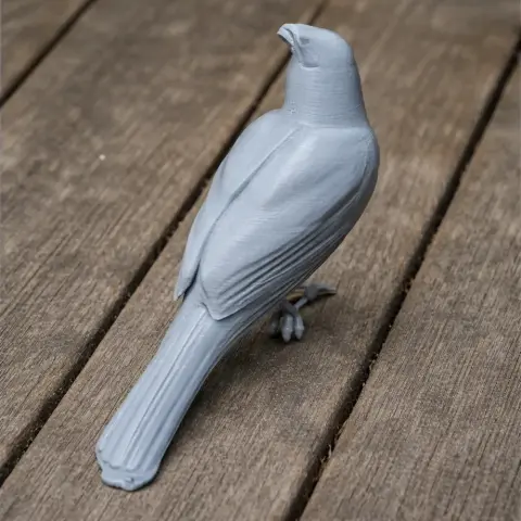 3D printed model of a prehistoric bird with detailed feathers, standing on wooden surface.