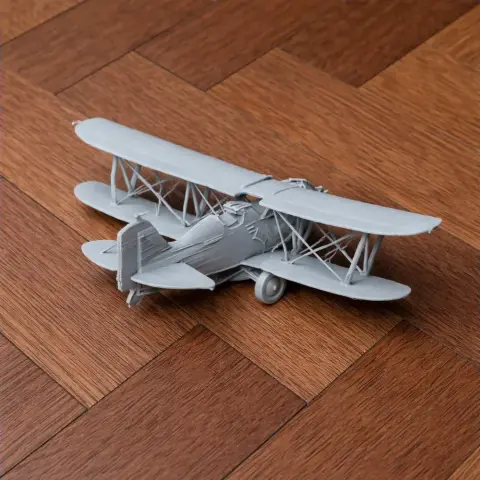 3D printed Curtiss F11C Goshawk model airplane on a wooden surface.