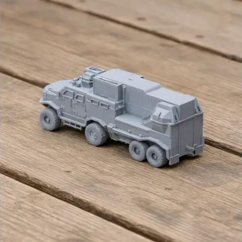 Gray, six-wheeled armored truck model with detailed parts, displayed on a wooden surface.