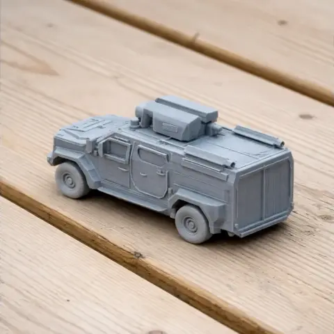 Gray 3D-printed military vehicle model on a wooden surface.
