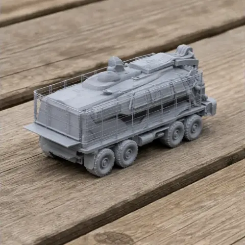 3D printed model of a Buffalo mine-protected vehicle on a wooden surface.