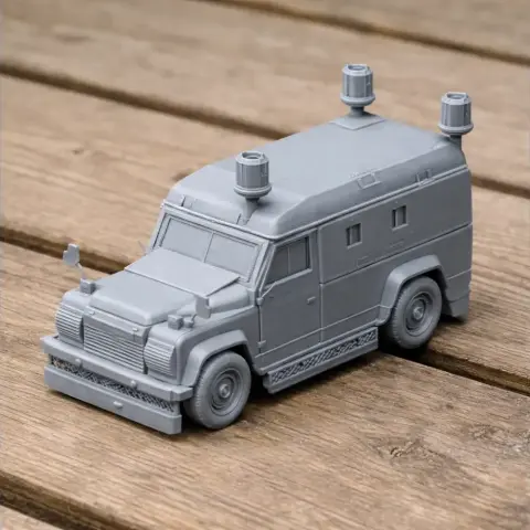 3D-printed model of an armored Land Rover Tangi with rooftop details, resting on a wooden surface.
