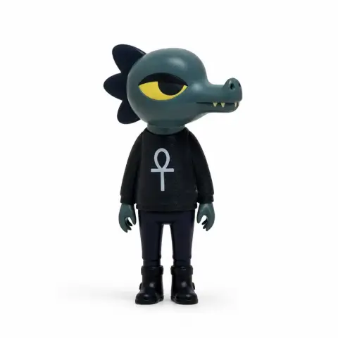 Anthropomorphic alligator figure with a black shirt featuring an ankh symbol, from 'Night in the Woods.'