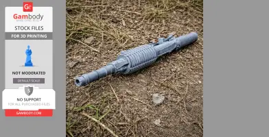 Gray 3D-printed assault rifle prop lying on dirt and grass.