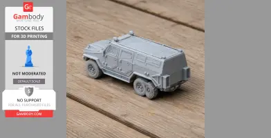 A gray 3D-printed model of an Iraqi light armored vehicle on a wooden surface.