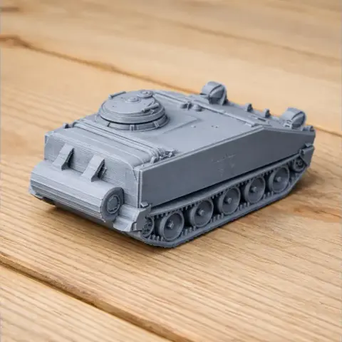 3D printed model of an M114 armored fighting vehicle with detailed tracks and turret on a wooden surface.