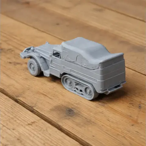 Gray 3D-printed M3 half-track tank model on a wooden surface.
